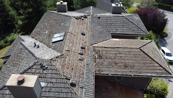 An aging roof with heavy moss growth on a home in Bellevue, WA