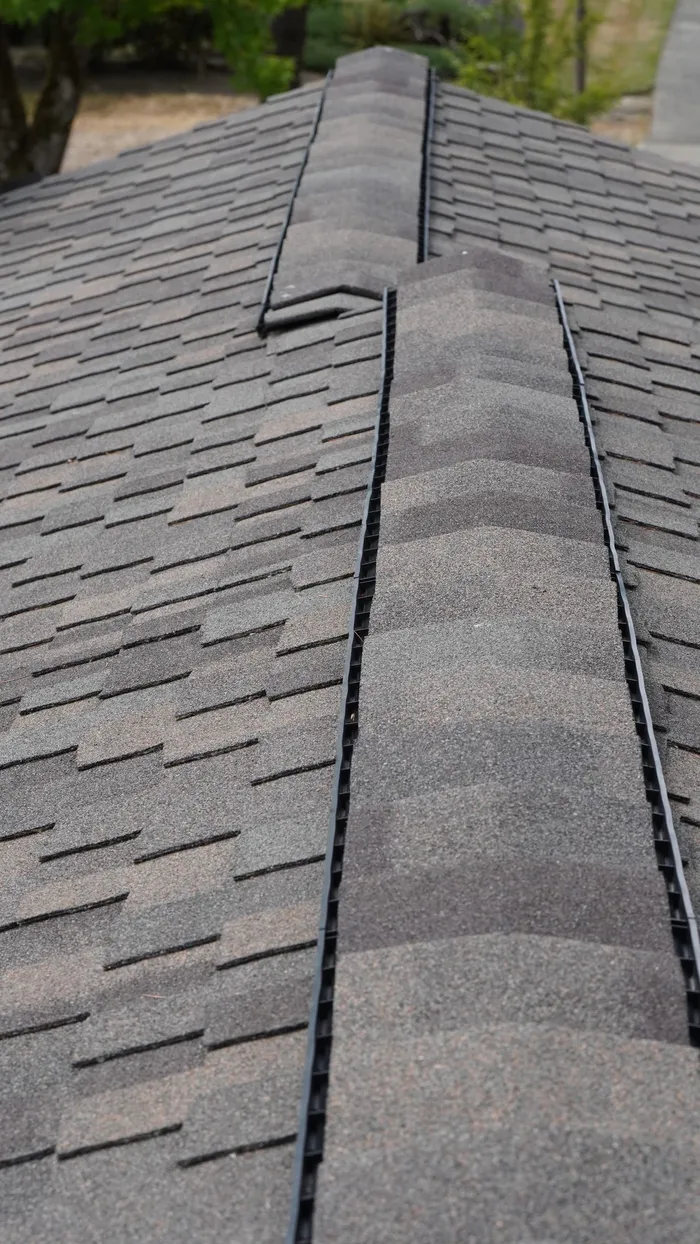 Close-up of new ridge cap shingles over a ridge vent on an asphalt shingle roof